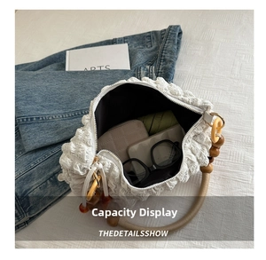 Intérieur spacieux d'un sac à bandoulière blanc plissé avec téléphone et parapluie
