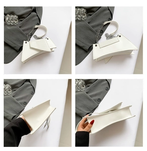 Détails d'un sac à main géométrique blanc avec gaufrage croco et chaîne argentée
