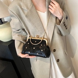 Pochette retrò nera con borchie a cuore dorate e una sottile catena di metallo dorato