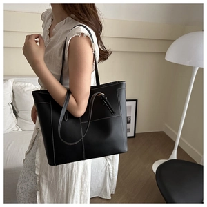Détail du sac cabas en cuir noir avec surpiqûres blanches et bandoulière élégante