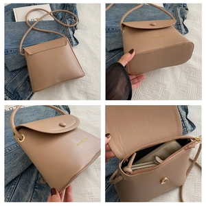 Detail view of khaki bucket bag showing back, base, interior capacity and snap closure