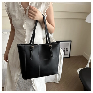 Détail du sac cabas en similicuir noir avec surpiqûres contrastées et bandoulière