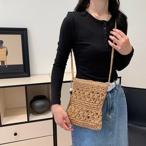 Bohemian handwoven straw crossbody bag with floral crochet pattern and tassel details