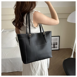 Détail d'un sac cabas noir vintage avec coutures contrastées et boucle dorée élégante
