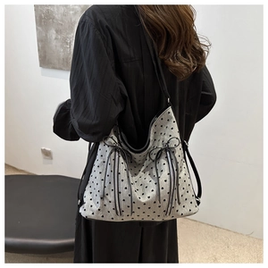 Gray tote bag with black heart prints, bow accents, and dual zipper detail for women