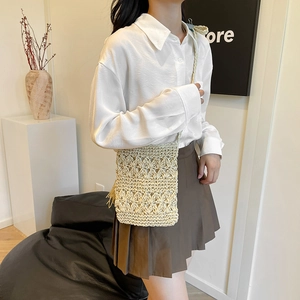 Bohemian woven straw crossbody bag with floral texture and tassel for beach vacations
