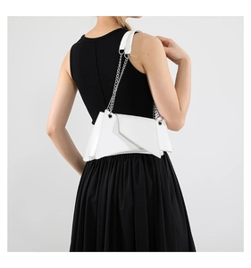 Vue de dos du mannequin portant un sac géométrique en cuir blanc à chaîne argentée
