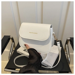 Detail view of a white semi-circular saddle bag on a chair in a minimalist home setting