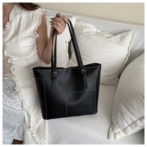 Détail du sac cabas noir avec coutures blanches contrastées et boucle en métal doré