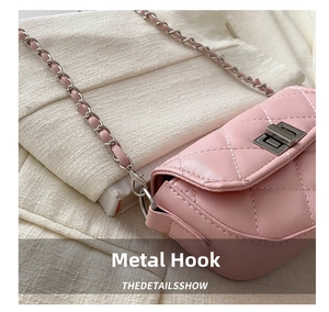Détail du sac matelassé rose montrant le crochet métallique argenté et la bandoulière chaîne