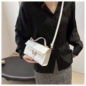 Sac bandoulière blanc en similicuir avec double fermeture éclair porté par modèle