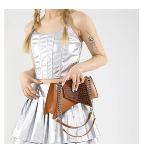 Détail du sac à main marron à motif crocodile avec chaîne argentée et textures en cuir