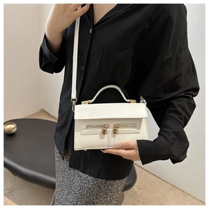 Sac bandoulière blanc rétro avec serrures dorées et bandoulière ajustable sur modèle