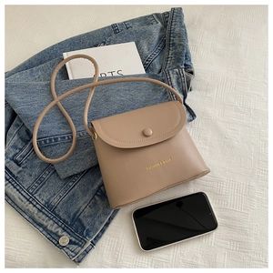 Detailed top view of a brown minimalist mini crossbody bag with a circular snap fastener