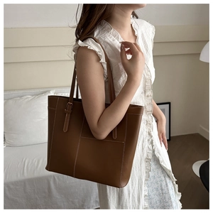 Détail du sac cabas marron caramel avec coutures contrastées et bandoulière réglable