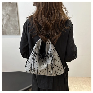 Close-up of gray minimalist backpack with black heart patterns and long zipper pulls