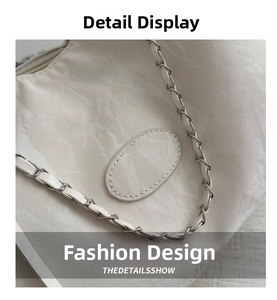 Macro shot of silver metal chain strap and white marbled texture on women's shoulder bag