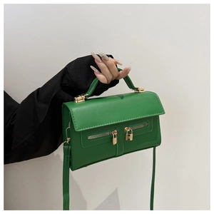 Détail du sac à main vert rectangulaire avec doubles fermetures et cadenas dorés
