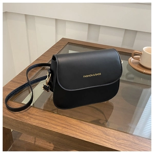 Detail of black faux leather crossbody bag with gold Fashion & Bags lettering on front