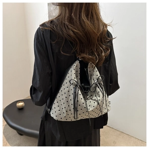 Detail of grey textured fabric tote with black heart print and dual side zippers