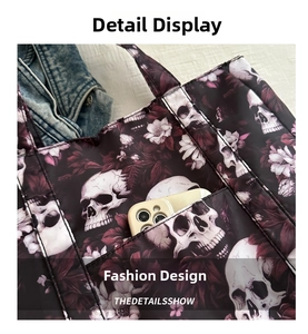 Detail shot of the skull print tote bag front pocket with a smartphone inside