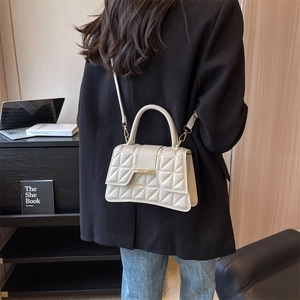 Détail du sac à bandoulière matelassé beige avec fermoir doré et bandoulière