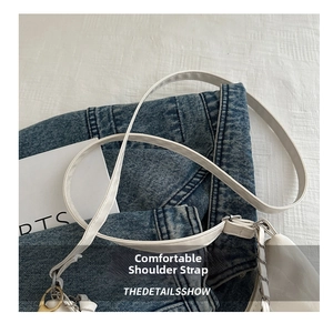 Close-up of smooth white leather shoulder strap with fine stitching on a tote bag