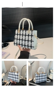 Detail of white checkered tweed tote bag with round handles and gold hardware accents