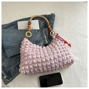 Détail du sac à main lilas froncé avec poignée en bois et charms bohèmes perle