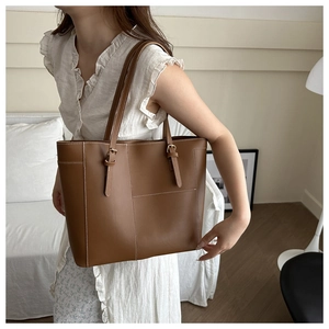 Détail du sac fourre-tout en cuir fauve avec texture lychee et surpiqûres blanches