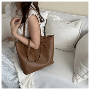 Sac fourre-tout en cuir marron avec surpiqûres blanches dans un cadre de vie élégant