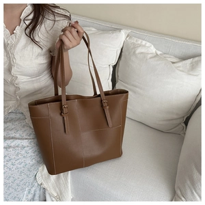 Détail du grand sac cabas marron foncé avec surpiqûres blanches et boucles dorées
