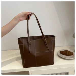 Détail du grand sac cabas marron foncé avec surpiqûres et boucle dorée ajustable