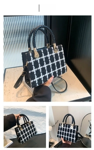 Detail view of black and white tweed crossbody bag with golden hardware and leather trim