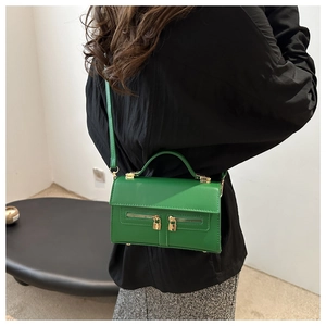 Détail macro du sac à main vert émeraude avec fermetures éclair et cadenas doré élégant