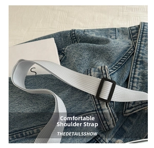 Détail de la bandoulière réglable gris clair avec une boucle noire robuste en gros plan