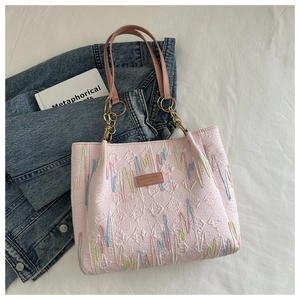 Détail du sac cabas rose matelassé avec broderie zigzag multicolore et logo chic