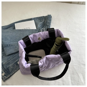 Vue intérieure d'un sac cabas lilas matelassé avec parapluie, portefeuille et lunettes