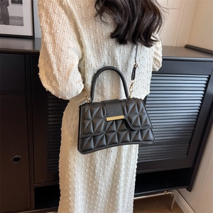 Fashionable black quilted shoulder bag with gold hardware and geometric textured finish
