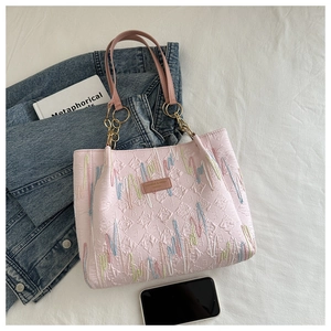 Détail du sac cabas rose avec motif en losange et broderie de vagues arc-en-ciel