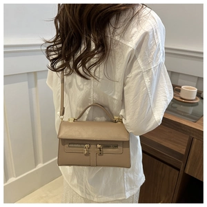 Sac bandoulière beige chic avec double fermeture éclair porté par un mannequin élégant