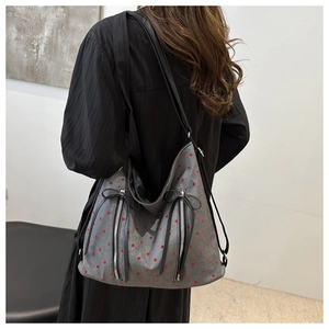 Close-up of grey canvas tote bag with red polka dots and black bow zipper detail