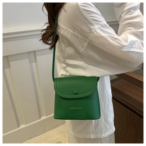 Detail of green leather crossbody bag with flap closure and Fashion & Bags embossed logo