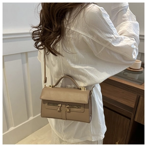 Détail du sac à bandoulière en cuir kaki avec double fermeture éclair et cadenas