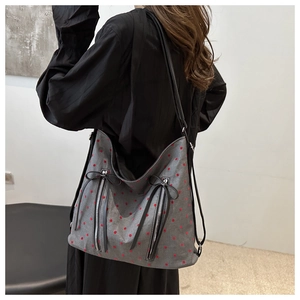 Detailed back view of a grey tote bag with red polka dots and decorative zippers