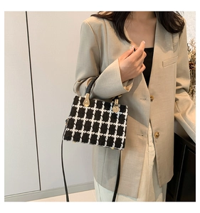 Classic black and white tweed crossbody bag with elegant gold hardware and top handle