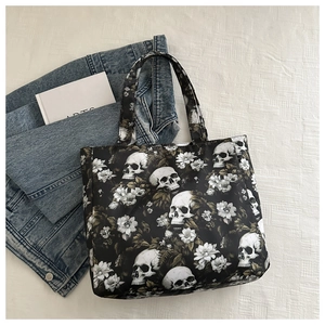Detail of black tote bag featuring retro skull and floral print against art decor