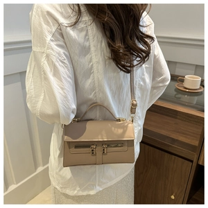Détail du sac bandoulière en cuir kaki avec double fermeture éclair et cadenas en métal