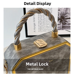 Close-up of geometric gray textured handbag with gold feather-carved lock and braided handle