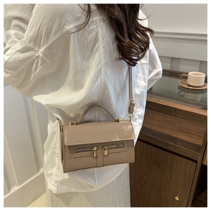 Détail du sac bandoulière beige en similicuir avec double fermeture éclair dorée